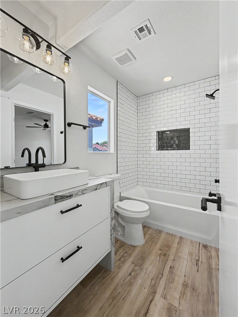8977 Paige Rene Court Las Vegas, NV 89117 - Photo 18 of 31 Refined bath featuring a vessel sink atop marble-look counters, complemented by a subway tile shower and durable vinyl flooring.