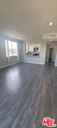 a view of empty room with window and wooden floor