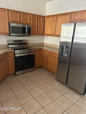 a kitchen with granite countertop a refrigerator and a stove top oven