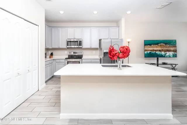 a view of kitchen with stainless steel appliances kitchen island sink refrigerator and stove