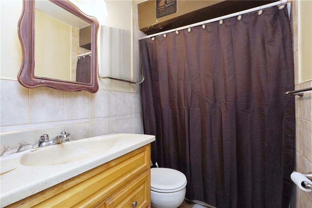 4 Ave Y Brooklyn, NY 11214 - Photo 8 of 25 a bathroom with a granite countertop sink vanity mirror and toilet