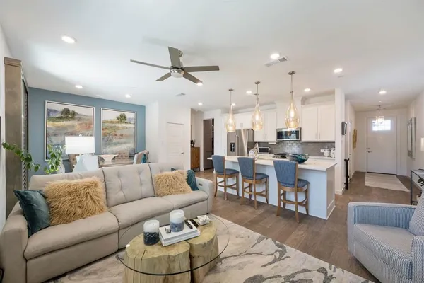 a living room with furniture kitchen and a chandelier