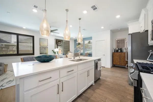 a kitchen with kitchen island a sink stainless steel appliances and a counter top space