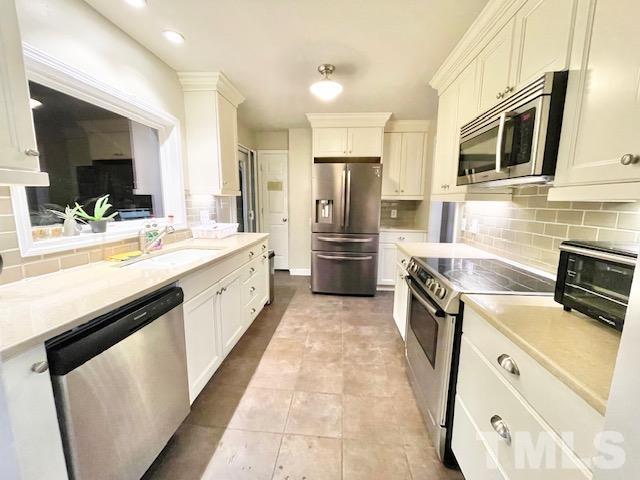 1020 Reca Road Garner, NC 27529 - Photo 4 of 20 a kitchen with stainless steel appliances a stove microwave and refrigerator