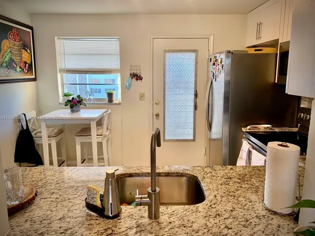 a kitchen with a sink and a refrigerator