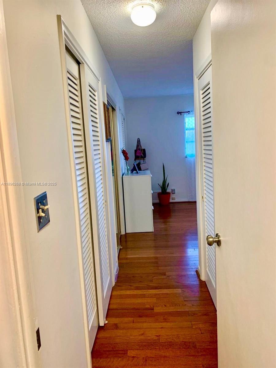 319 Northeast 14th Avenue, Unit 702 Hallandale Beach, FL 33009 - Photo 9 of 12 a view of a hallway with wooden floor and staircase