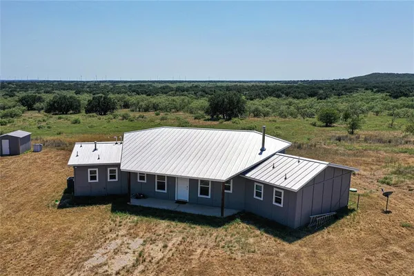 an aerial view of a house next to a big yard