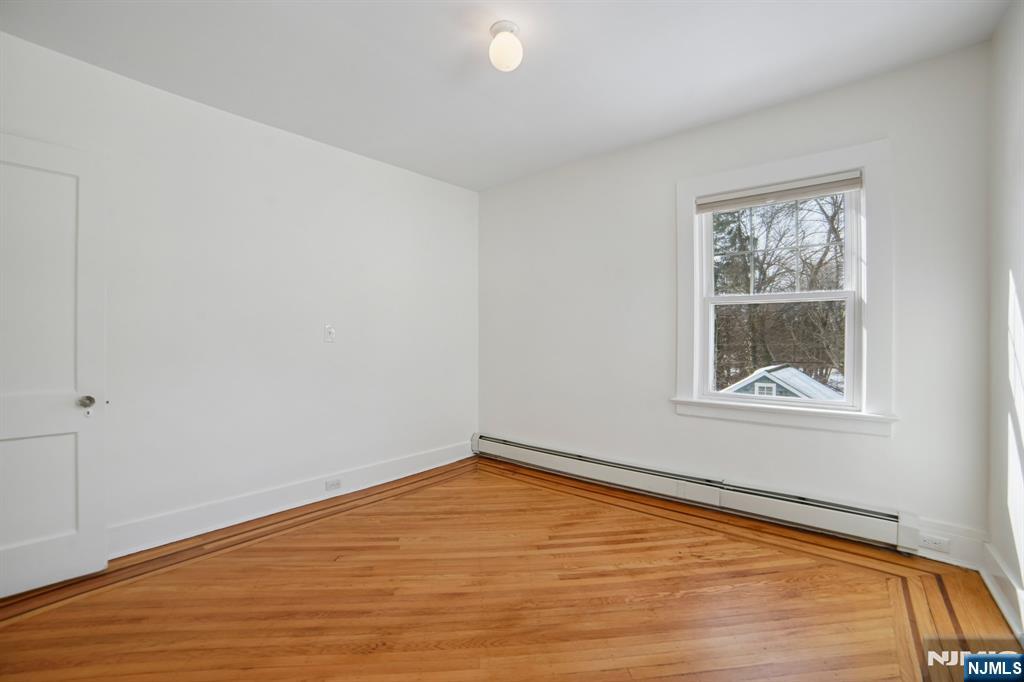42 Brookfield Road, Unit 2 Montclair, NJ 07043 - Photo 25 of 36 a view of an empty room with wooden floor and a window