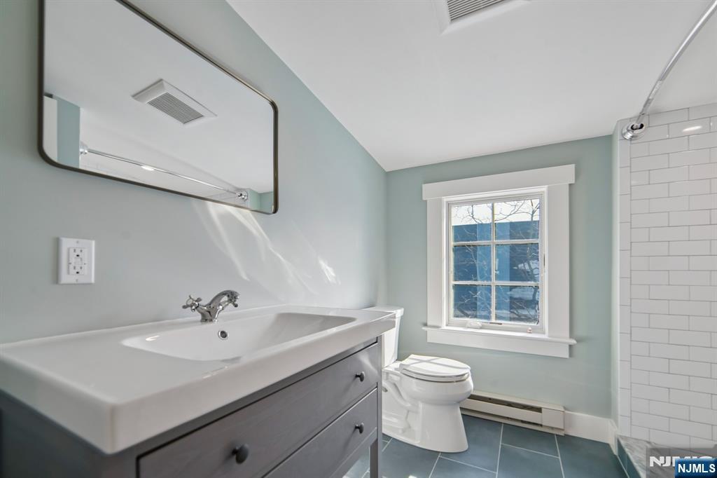 42 Brookfield Road, Unit 2 Montclair, NJ 07043 - Photo 30 of 36 a bathroom with a toilet sink a mirror and a window