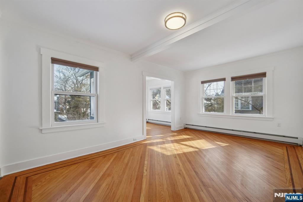 42 Brookfield Road, Unit 2 Montclair, NJ 07043 - Photo 6 of 36 a view of an empty room with window and wooden floor