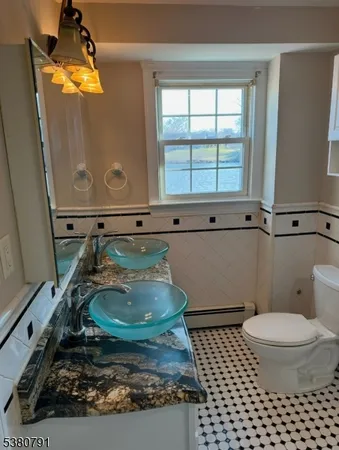 a bathroom with a sink a toilet and a mirror