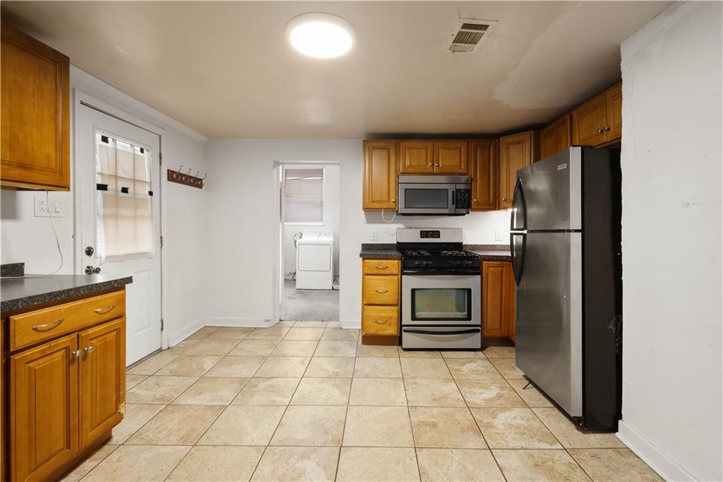 108 Pius Street Pittsburgh, PA 15203 - Photo 14 of 35 a kitchen with granite countertop a refrigerator and a stove top oven