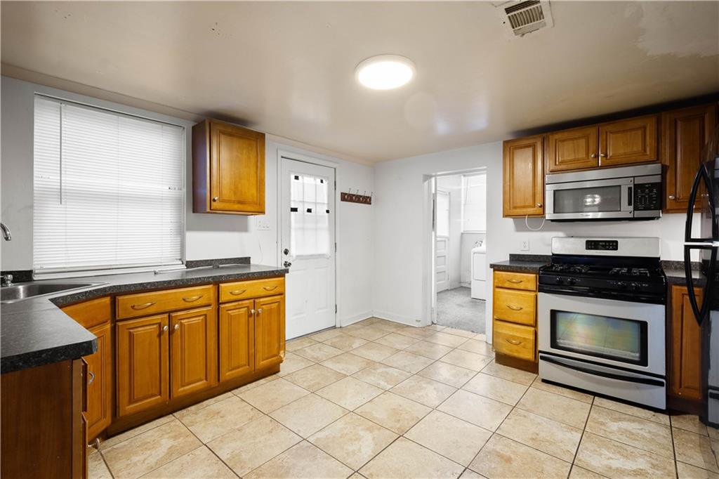 108 Pius Street Pittsburgh, PA 15203 - Photo 15 of 35 a kitchen with stainless steel appliances granite countertop a stove a sink and a microwave