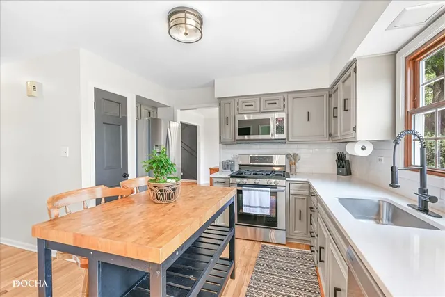 a kitchen with stainless steel appliances a dining table chairs and granite counter tops