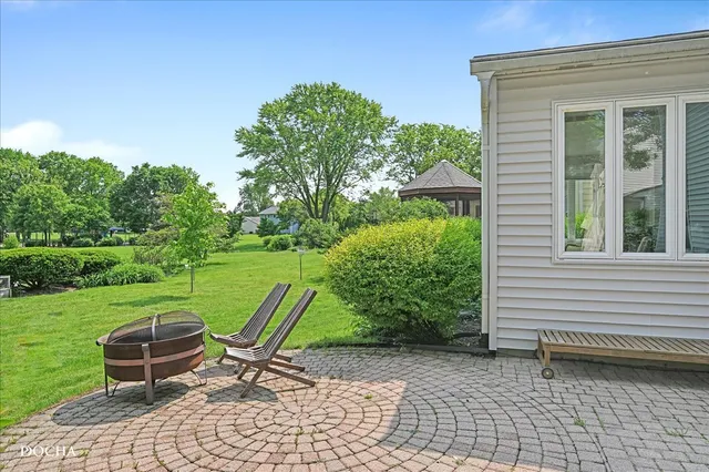 a patio with table and chairs and potted plants