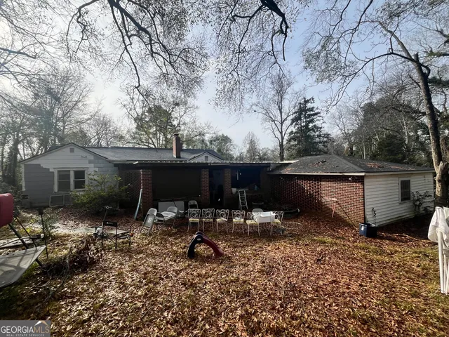 a backyard of a house with barbeque oven and outdoor seating