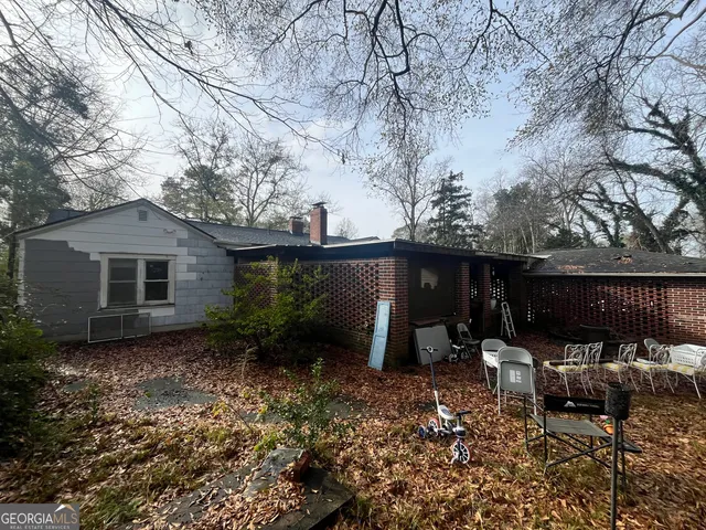 a backyard of a house with table and chairs