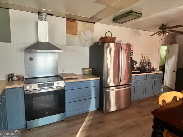 a kitchen with stainless steel appliances granite countertop a refrigerator and a stove
