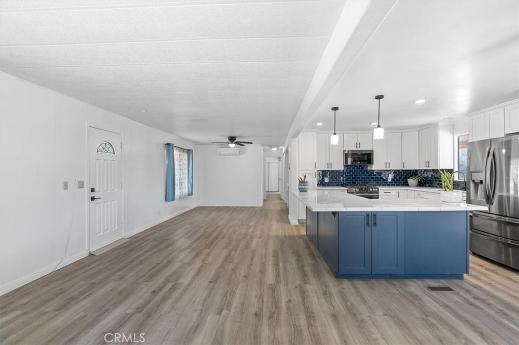 5405 Marjorie Street Weldon, CA 93283 - Photo 20 of 36 a large kitchen with stainless steel appliances kitchen island a large counter top and wooden floors
