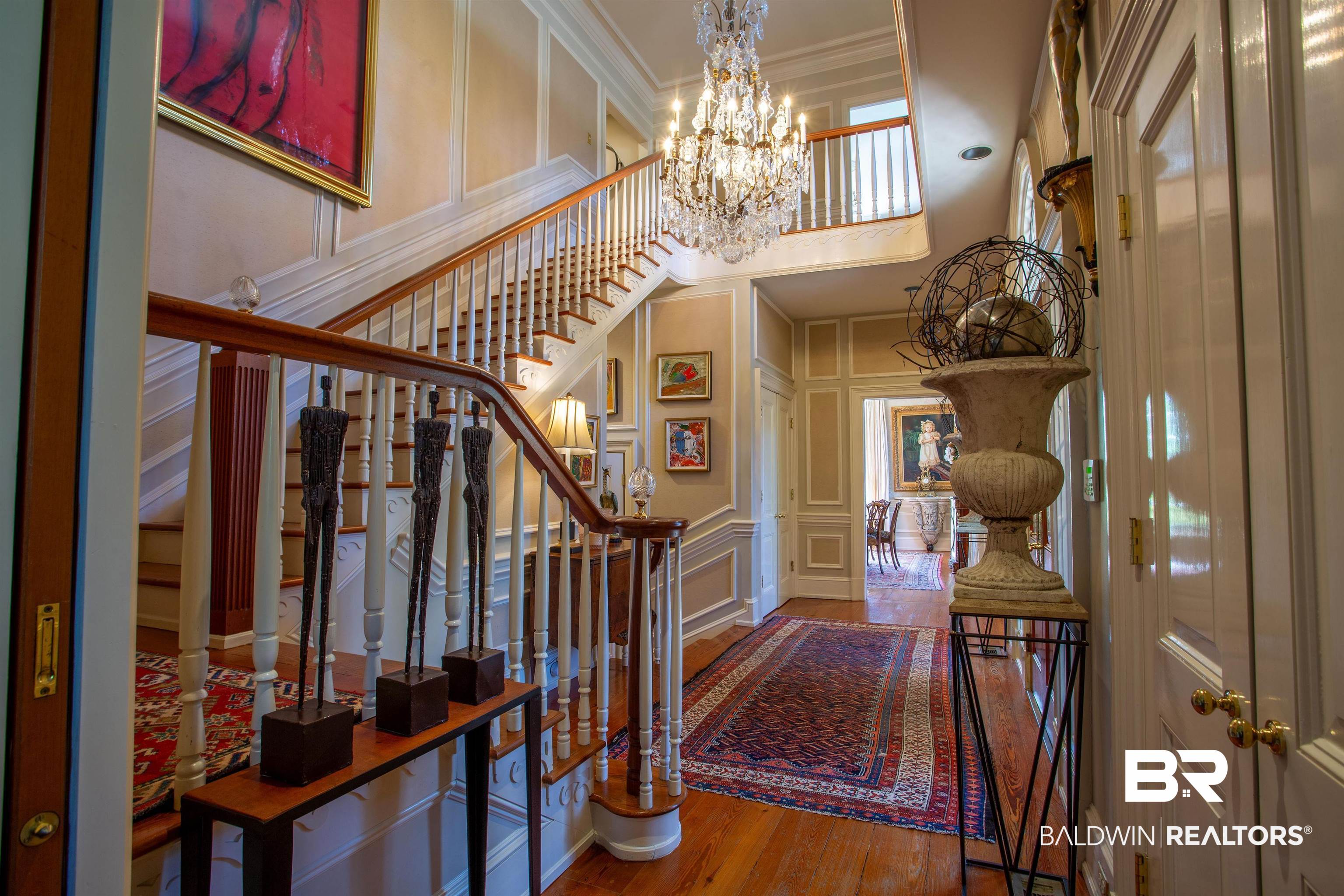 150 Austill Avenue Mobile, AL 36608 - Photo 11 of 39 Grand staircase with wood handrails, white balusters, and hardwood flooring