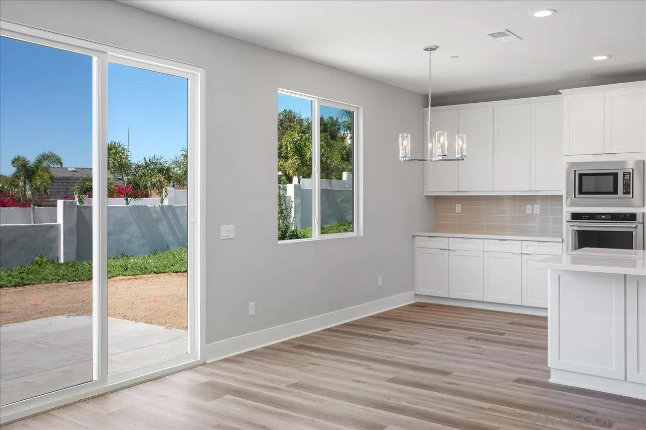 311 Brotherton Road Escondido, CA 92025 - Photo 14 of 33 a kitchen with kitchen island granite countertop a stove a sink and a wooden cabinets