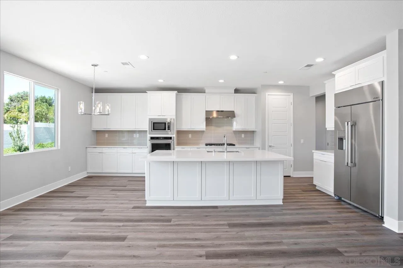 311 Brotherton Road Escondido, CA 92025 - Photo 8 of 33 a large kitchen with kitchen island a sink stainless steel appliances and cabinets