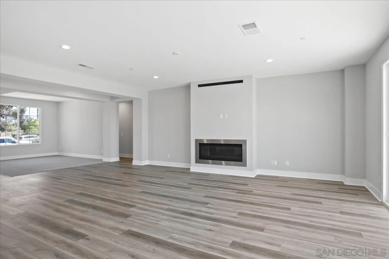 311 Brotherton Road Escondido, CA 92025 - Photo 10 of 33 a view of an empty room with wooden floor and a window