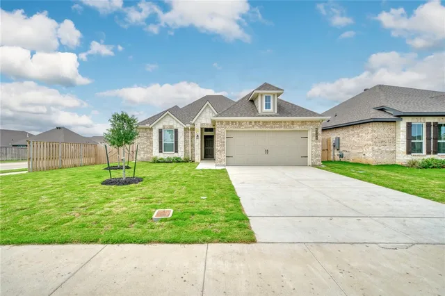 a view of a white house with a big yard and large trees