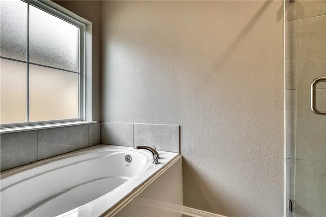 a bathroom with a tub and a window