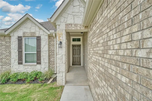 a view of a brick house with a large window and yard