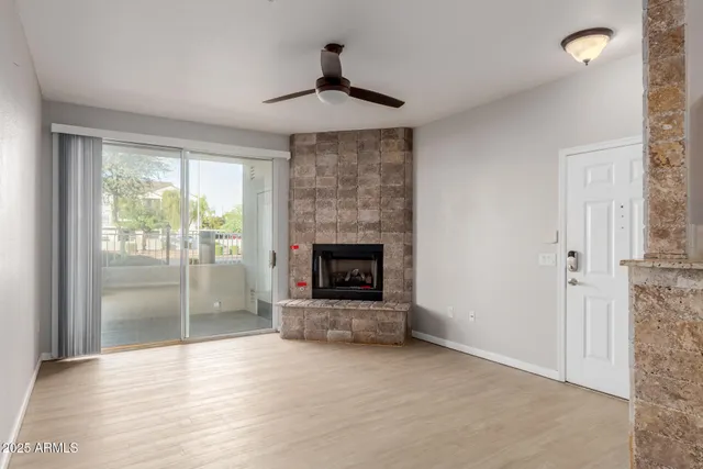 a view of an empty room with a fireplace and a window