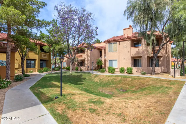 a front view of a house with a yard and palm trees