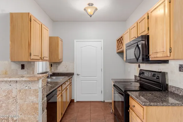 a kitchen with stainless steel appliances granite countertop a stove a sink and a microwave