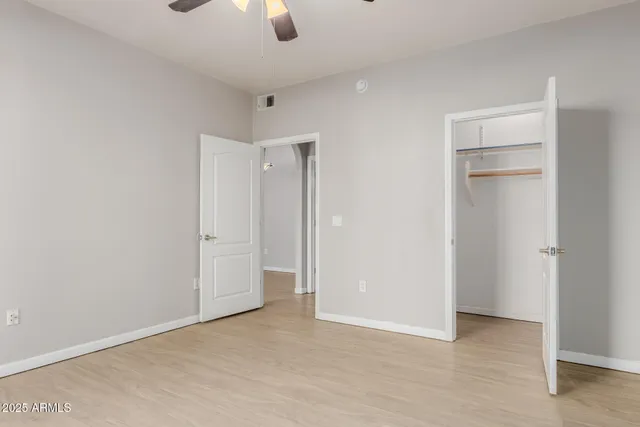 an empty room with closet and windows