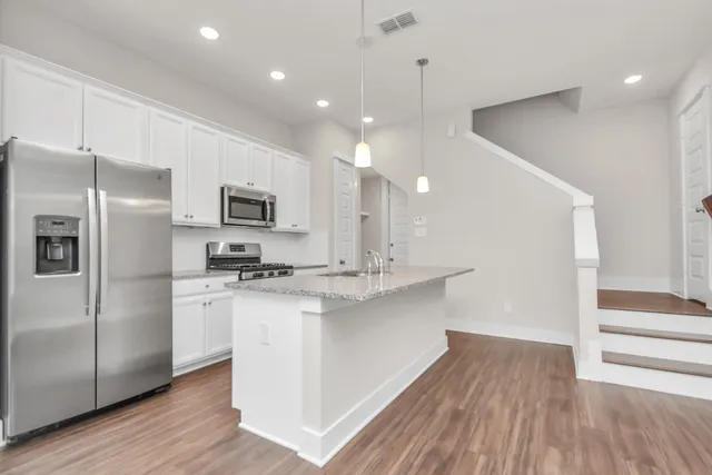 a kitchen with stainless steel appliances a refrigerator and a stove top oven