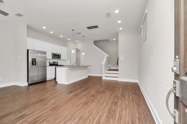 a view of kitchen with cabinets stainless steel appliances and wooden floor