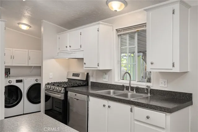 a kitchen with granite countertop white cabinets sink and white stainless steel appliances