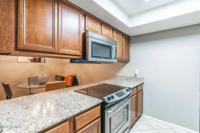 a kitchen with granite countertop a sink a window and cabinets