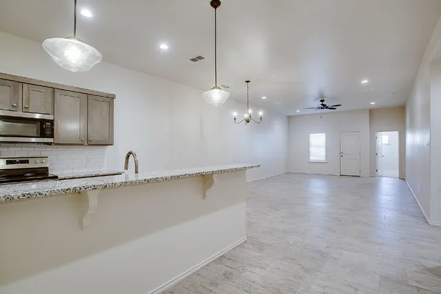 a view of a kitchen with a sink and chandelier