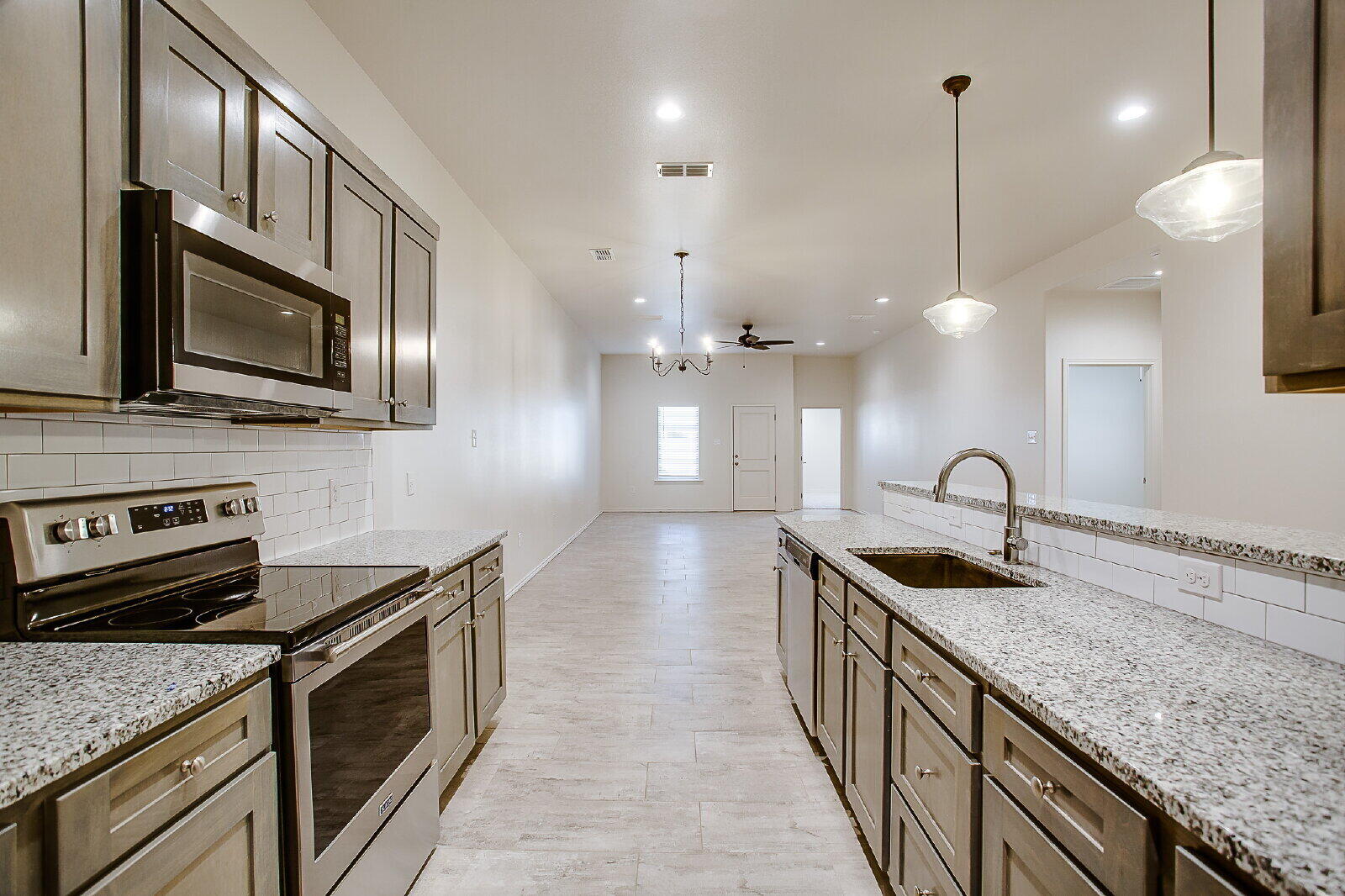 5520 121st Street, Unit B Lubbock, TX 79424 - Photo 5 of 17 a kitchen with stainless steel appliances granite countertop a sink a stove and oven