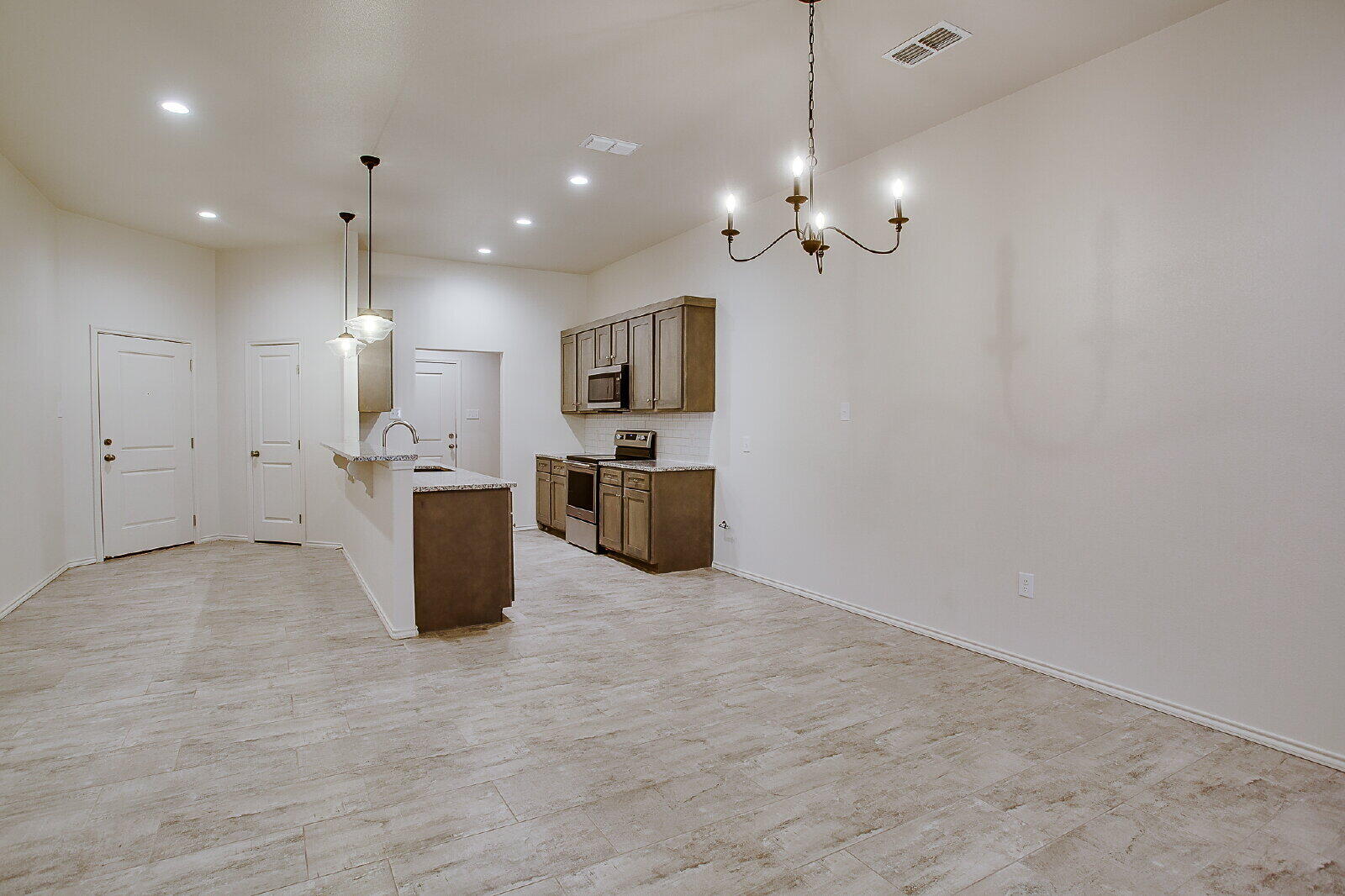5520 121st Street, Unit B Lubbock, TX 79424 - Photo 7 of 17 a kitchen with kitchen island a refrigerator and a sink