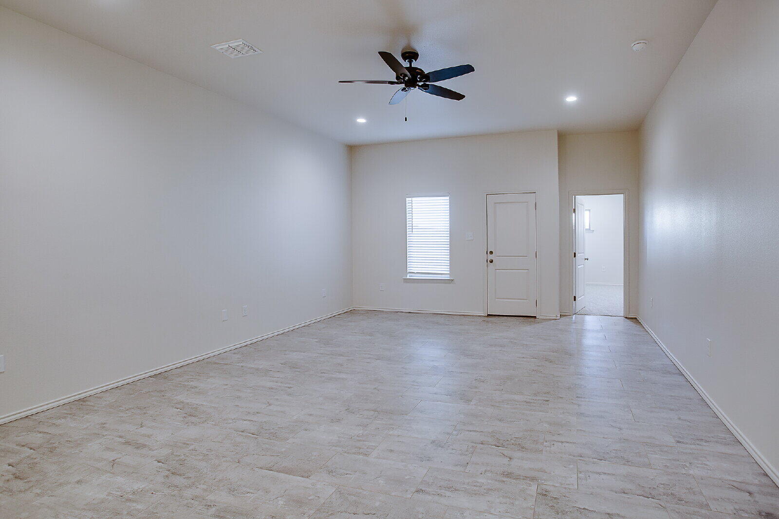 5520 121st Street, Unit B Lubbock, TX 79424 - Photo 8 of 17 an empty room with chandelier fan and windows