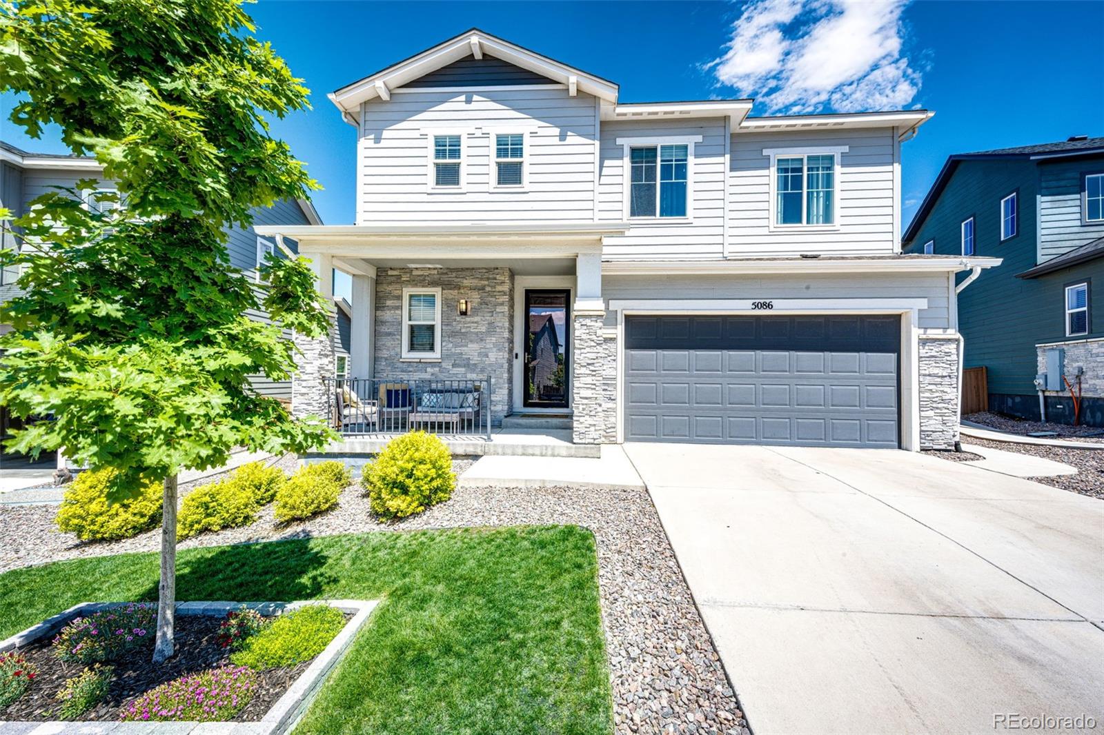 5086 Basalt Ridge Circle Castle Rock, CO 80108 - Photo 1 of 46 a front view of a house with garden and porch