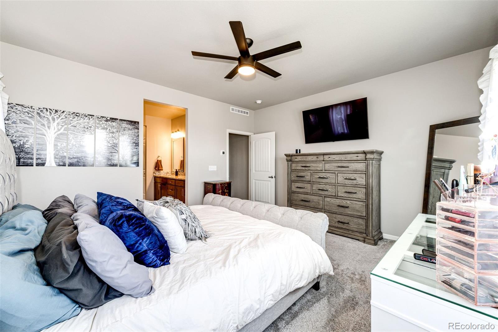 5086 Basalt Ridge Circle Castle Rock, CO 80108 - Photo 23 of 46 a spacious bedroom with a bed and a flat screen tv