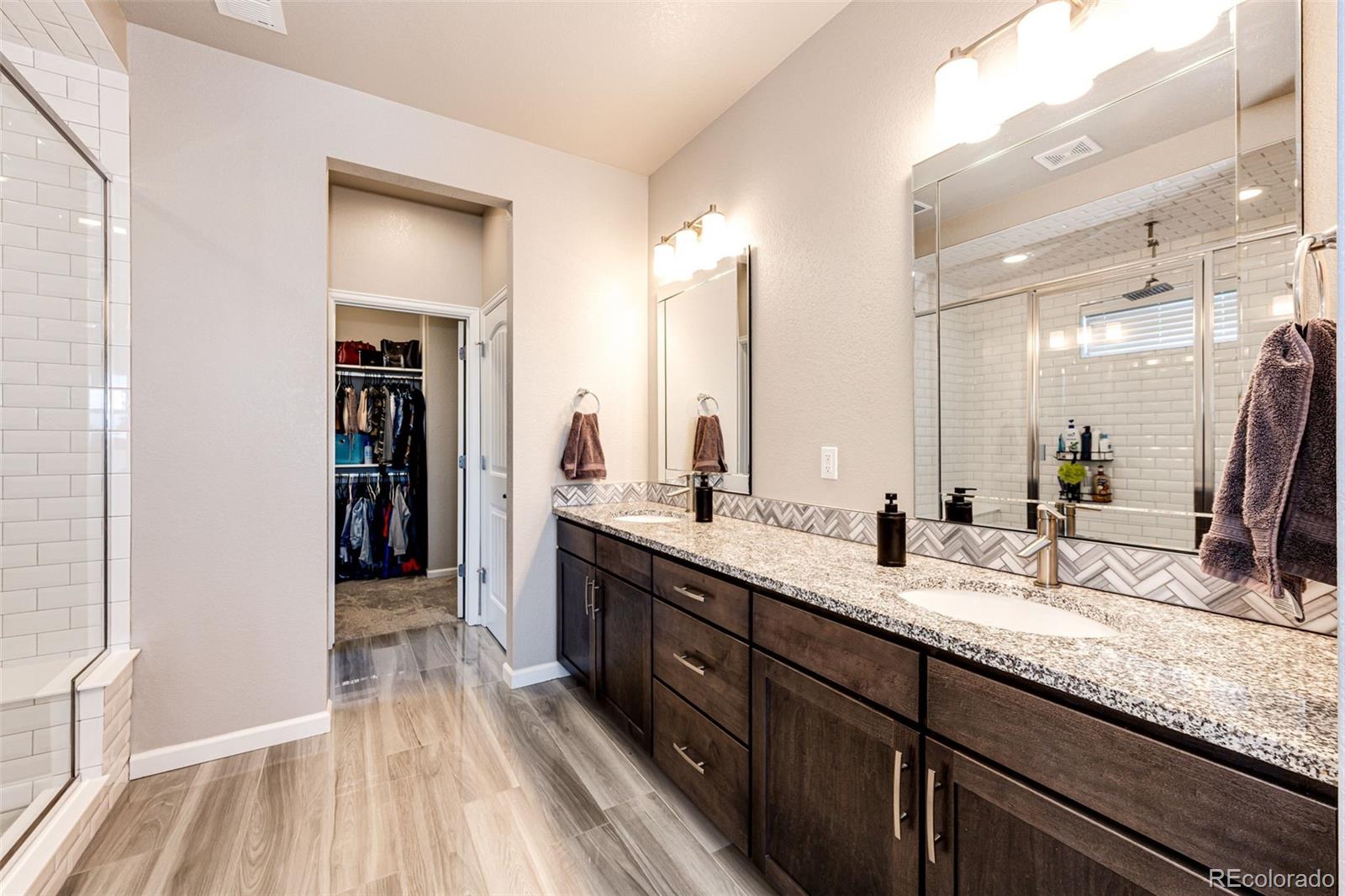 5086 Basalt Ridge Circle Castle Rock, CO 80108 - Photo 24 of 46 a bathroom with a double vanity sink and a mirror