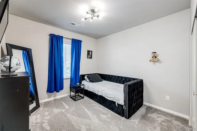 a bedroom with a bed and a flat tv screen on the dresser
