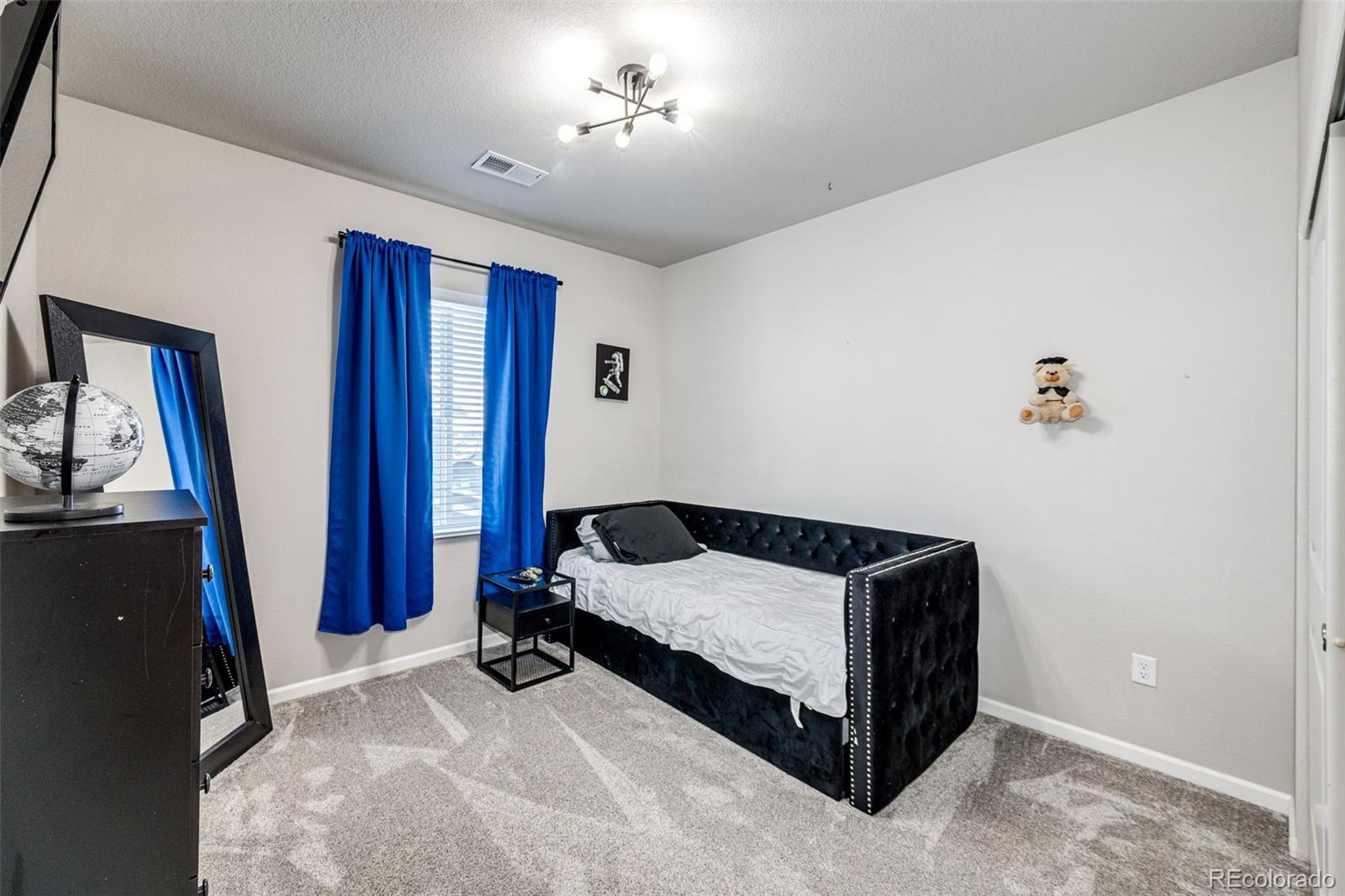 5086 Basalt Ridge Circle Castle Rock, CO 80108 - Photo 27 of 46 a bedroom with a bed and a flat tv screen on the dresser