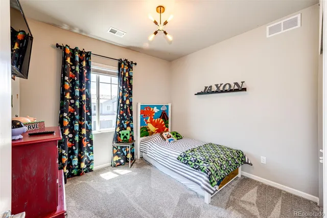 a bedroom with furniture and a flat screen tv