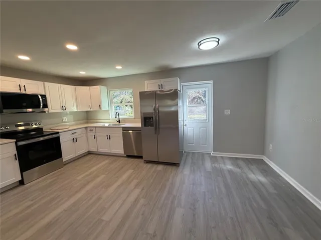 a kitchen with stainless steel appliances granite countertop a refrigerator and a stove top oven