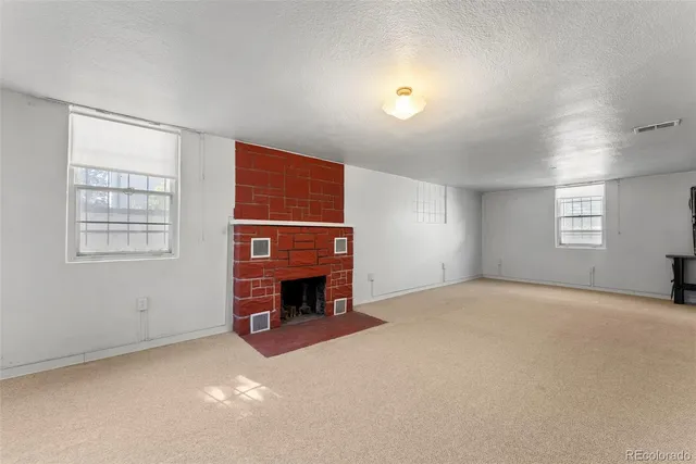 an empty room with windows fireplace and windows